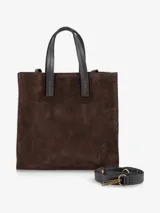 Cartera estructurada de formato cuadrado, confeccionada en gamuza color marrón oscuro. Presenta doble asa de mano fija en cuero liso negro y una correa larga regulable y desmontable en cuero negro con herrajes metálicos en tono bronce.