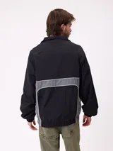 Rompevientos Rusty con cierre frontal, capucha y diseño de bloques de color en gris y verde militar. Cuenta con puños elásticos y logo de la marca en el pecho.