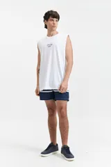 Musculosa blanca de algodón con corte oversize y estampado con texto en azul.