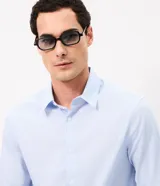 Camisa de corte regular para hombre, en color celeste con finas rayas verticales blancas. Cuenta con cuello camisero tradicional, mangas largas con puños abotonados y cierre frontal con botones.