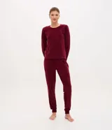 Pijama de dos piezas confeccionado en plush con textura acanalada y estampado de corazones en relieve. Incluye una blusa de cuello redondo con mangas largas y puños ajustados, y un pantalón con cintura elástica y puños en el ruedo.