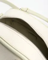 Cartera estilo baúl de color verde claro, combinada con tejido texturizado en el cuerpo principal y detalles en símil cuero. Cuenta con asas de mano rígidas, correa larga ajustable y extraíble, y herrajes metálicos plateados con el logo de la marca en la parte frontal.