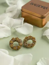 Aros de porcelana modelada a mano en forma de argolla decorada con apliques de flores, con perno de acero quirúrgico.