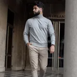 Polera de cuello alto confeccionada en tejido de algodón con spandex, de corte ajustado, con puños y ruedo acanalados.