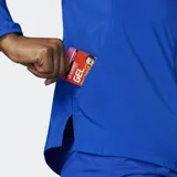 Campera de running Adidas Adizero Essentials color azul, con cierre frontal, cuello alto y logo de la marca en blanco. Cuenta con paneles perforados bajo los brazos para mayor transpirabilidad y bolsillos laterales con cierre.