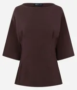 Blusa de manga 3/4 color marrón oscuro, con cuello redondo y corte holgado (oversize). Presenta pliegues verticales a los costados.