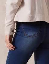 Jean de tiro alto, color azul, con corte bootcut y bolsillos delanteros y traseros.