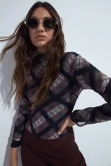 Body de manga larga con cuello alto, confeccionado en tejido de malla elástica con estampado de cuadros en tonos marrones, negros y blancos.