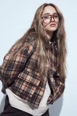 Campera de paño con diseño de cuadros en tonos negro, gris y beige. Presenta cuello camisero, cierre frontal con botones y corte corto.