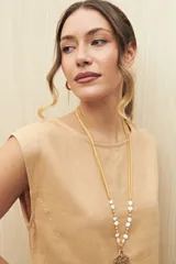 Top sin mangas de lino y viscosa, color negro, con escote redondo y caída relajada. Presenta hombros levemente marcados y botones forrados en la espalda.