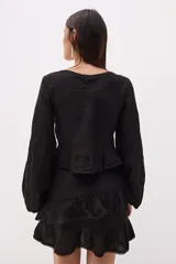 Top corto de lino italiano a rayas verticales beige y blanco, con escote en V, jareta ajustable con lazo en el centro delantero y volado en el ruedo. Mangas largas estilo globo con puños elásticos.