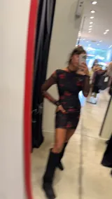 Vestido corto ajustado negro con diseño de rosas rojas, escote off-shoulder y mangas largas de red transparente.