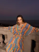 Conjunto de dos piezas compuesto por un top corto de mangas abullonadas con elástico y una falda corta con volados, ambos confeccionados en tela estampada a rayas multicolores.