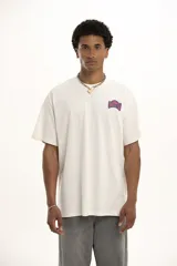 Remera color crudo de corte holgado con estampado pequeño en el pecho.