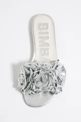 Sandalias plateadas con base plana y adorno de flores con volados en el empeine.