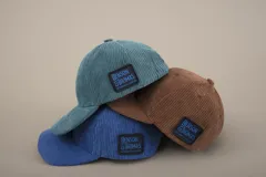 Gorra de pana color petróleo con visera curva y logo de la marca bordado en el lateral.