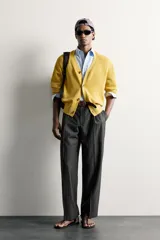 Pantalón de vestir gris con diseño de rayas sutiles, de corte relaxed fit, con pinzas delanteras y trabillas para cinturón.