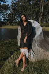 Pollera midi negra con detalle de cuero calado y flecos blancos en el ruedo.