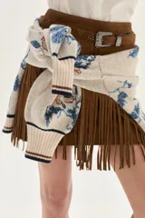 Cardigan de tejido de punto color crudo con diseño de jacquard floreado en tonos azules y marrones. Presenta cuello en V, cierre frontal con botones y ribetes a rayas en cuello, puños y bajo.