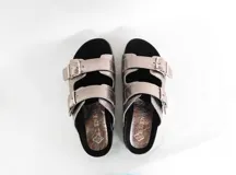 Sandalias de cuero color peltre con doble tira ancha ajustable con hebillas metálicas. Suela de corcho y base de goma.