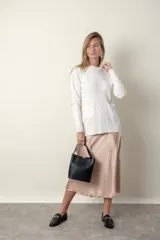 Sweater blanco de punto trenzado con cuello redondo y mangas largas.