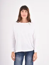Remera de manga larga con cuello redondo, confeccionada en tejido liviano de textura suave y corte holgado.
