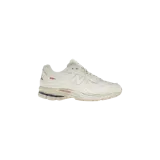 Championes urbanos New Balance modelo 2002R Protection Pack, color blanco off-white, con diseño de paneles desgastados, suela texturizada y detalles en la mediasuela.
