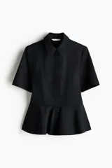 Camisa de manga corta de popelina de algodón en color negro, con cuello camisero, botonadura oculta y diseño con peplum acampanado en la cintura.