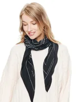 Pañuelo o pashmina cuadrado, color negro con estampado de líneas blancas que simulan costuras o puntadas. El tejido es plisado.