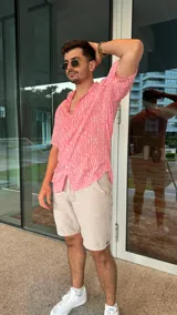 Camisa de fibrana color rosa con estampado de líneas verticales blancas, de manga corta y cuello clásico.