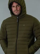 Campera acolchada verde militar con capucha, cierre frontal con cremallera y bolsillos laterales con cremallera.