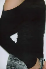 Top de tejido suave con diseño asimétrico, escote descubierto en un hombro y manga larga.