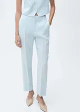 Pantalon de vestir de corte recto y tiro alto, confeccionado en lino color celeste. Presenta cierre oculto con botón, gancho y cremallera, trabillas para cinturón, bolsillos laterales y bolsillos de ribete en la parte posterior.