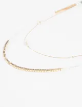 Collar largo doble con cadena dorada y detalles de perlas.