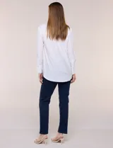 Camisa de calce relajado color celeste, confeccionada en tejido de textura suave y fluida. Presenta cuello camisero y abotonadura frontal, mangas largas con puño ancho y ruedo curvo.
