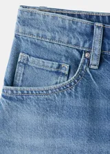 Short de denim azul de tiro medio, con diseño recto y clásico de cinco bolsillos, presillas para cinturón y cierre frontal con botón y cremallera.