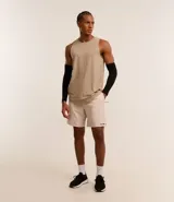 Bermuda deportiva masculina de corte estándar, con cintura elástica y cordón ajustable. Presenta un diseño minimalista en color beige con bolsillo trasero y detalle de estampa pequeña en el ruedo.