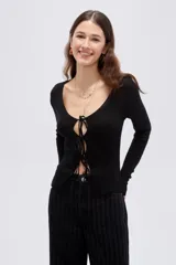 Top de manga larga en tejido de punto con lurex, color negro, de corte ajustado al cuerpo, con escote en V pronunciado y cierre delantero mediante finos lazos para anudar.