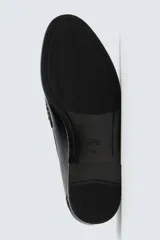 Mocasín de vestir negro, con acabado liso y brillante, puntera cuadrada y detalle de antifaz en el empeine. Posee suela fina y tacón bajo.