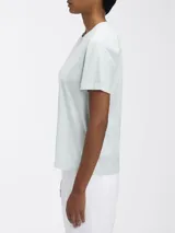 Remera de algodón orgánico de manga corta y cuello redondo, color celeste pálido. Presenta un pequeño logo tonal de Calvin Klein en la parte superior central del pecho.