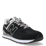 Championes urbanos New Balance modelo 574, color negro con detalles en gris y blanco. Confeccionados en una combinación de gamuza y malla, presentan el logo 'N' característico en los laterales, entresuela con tecnología ENCAP para mayor amortiguación y cierre mediante cordones.
