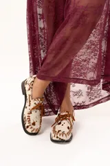 Zapato náutico de horma cuadrada confeccionado en cuero de pelo de vaca con estampado animal print. Presenta detalles de pasamanería en cuero descarne en el frente y laterales, cordones frontales y suela plana con pequeño taco.