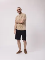 Remera color beige con cuello henley de tres botones y mangas cortas. Diseño estoneado.