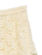 Falda midi de encaje color crema con diseño asimétrico de capas superpuestas y corte irregular.
