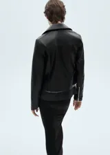 Chaqueta de diseño biker en efecto piel color negro, con solapas con muesca, cierre cruzado con cremallera y bolsillos laterales con cremallera.