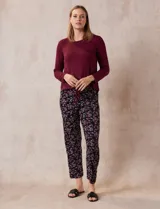 Conjunto de pijama marca René Rofé, compuesto por remera negra de manga larga con bolsillo en el pecho y pantalón largo con estampado animal print, cintura elastizada y lazo de ajuste.