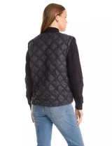 Campera combinada Current Air, con torso acolchado en diseño de rombos y mangas de tejido de punto grueso con diseño de ochos. Presenta cierre frontal metálico, cuello alto y puños y ruedo acanalados.