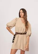 Vestido corto color beige, de corte oversize, con escote en V y mangas globo. Incluye cinturón marrón con hebilla dorada.