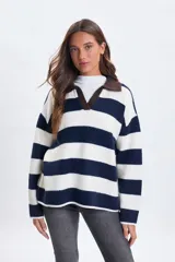 Sweater de punto con diseño de franjas horizontales anchas en azul marino y blanco. Presenta un cuello tipo polo en color bordó con escote en V y mangas largas de corte holgado.