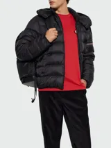 Campera puffer Moncler modelo Ravenlock, color negro, con diseño acolchado horizontal, capucha desmontable y cierre frontal.